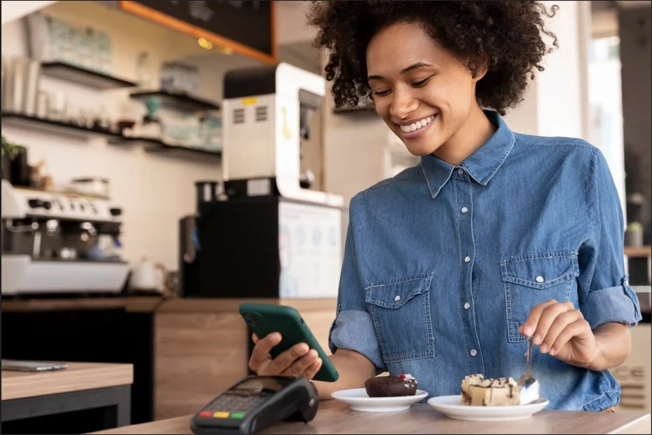 Customer using a smartphone for mobile payments at a cafe POS terminal, ideal for modern retail and restaurant
