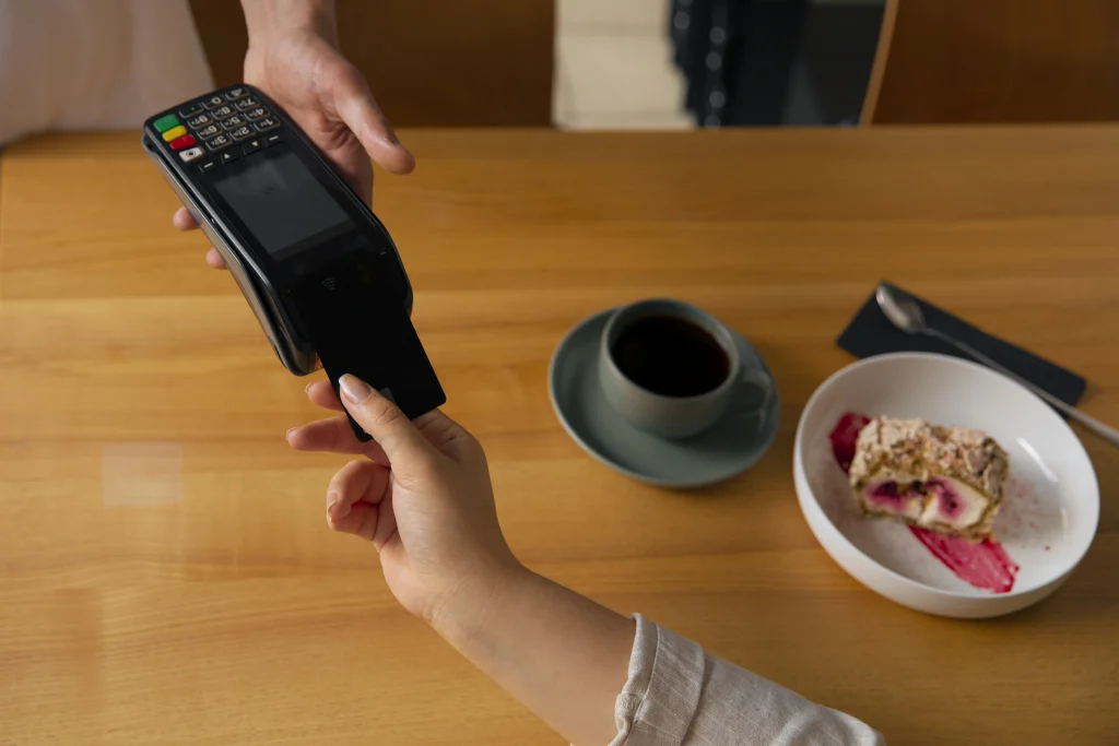 high-angle-customer-paying-with-nfc-device