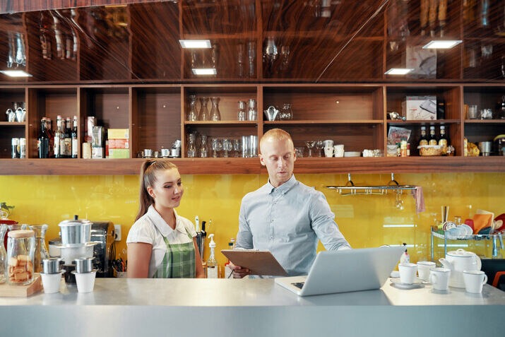 Cafe owner managing sales with a modern restaurant POS system.