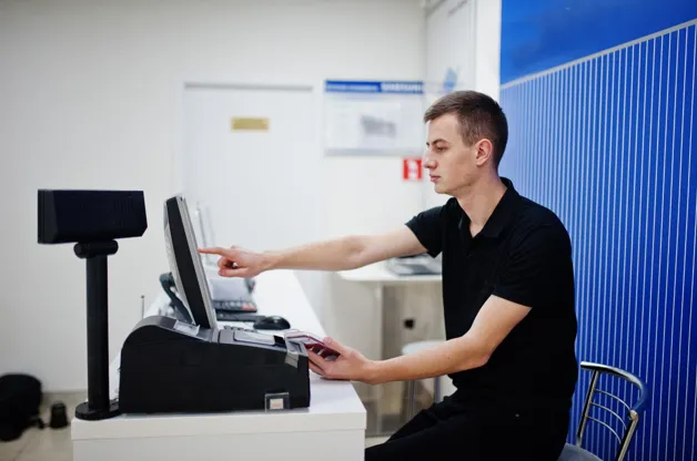 Cashier operating modern retail POS checkout system