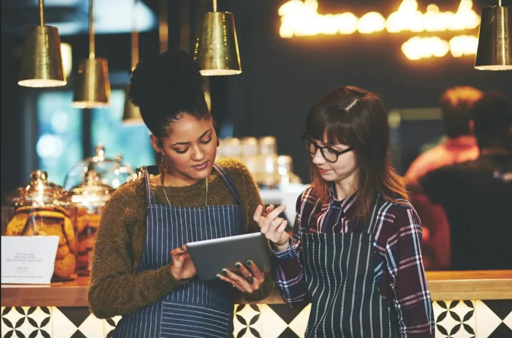 Coffee shop staff using POS tablet